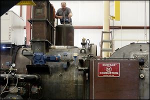 Assembler Bernie King works on a multichamber vacuum furnace at Surface Combustion’s Waterville factory.