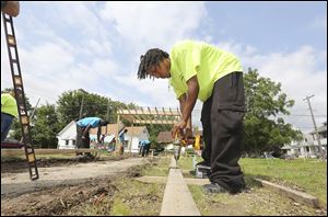 Chuck Phoenix, 22, assembles a form as he and other young men in job training programs help build a walkway.