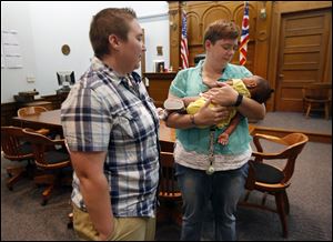 Joann Jakeway, left, and her wife Gina Jakeway, right, in the courtroom of Lucas County Probate Court Judge Jack Puffenberger with their 6-month-old baby girl named Devyn.