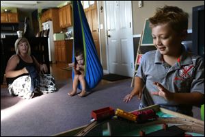 “It's working towards a purpose,” Erin Luetzow said about the PLAY therapy she uses to help her autistic sons, Kruze, 3, center, and Gage, 4, right. The program includes using their self-directed play to help work on their impairments.