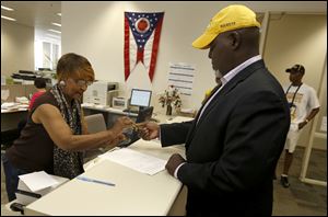 June Boyd collects the mayoral candidate petitions from former mayor Mike Bell at the Lucas County Board of Elections.