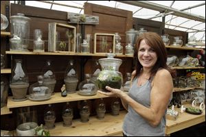 Theresa Hoen, of Hoen’s Garden Center and Landscaping, shows some of the many terrarium the center sells.