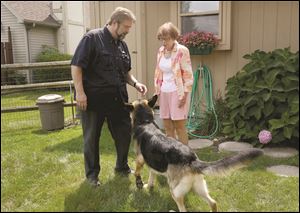 Ma & Paws Pet & House Sitting owner John Hauman, left, speaks with the owner of 5-year-old German Shepherd Charger, Pamela McElheney, right.