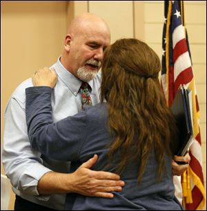 Thomas Ilstrup, President, Washington Local School Board hugs Jackie Semelka, right, who passed out individualized letters to each member of the school board.
