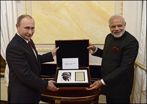 Russian President Vladimir Putin, left, and Indian Prime Minister Narendra Modi pose for a photo while exchanging official gifts during their meeting in the Kremlin in Moscow Wednesday.