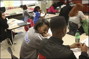 Candace Spencer, 16, center, jokes with Eric Hodge, 15, during Woodward’s college prep class.