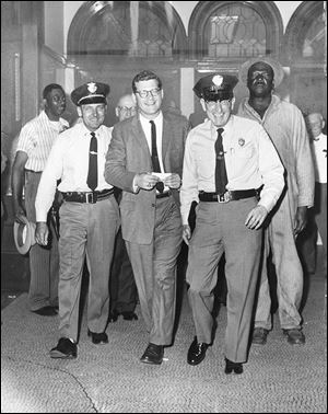 Lt. Eugene Nusbaum, left, and Deputy Leo Lehman escort Merritt W. ‘Tim’ Green II after he was fined and jailed for contempt of court in 1960. Mr. Green died Saturday at his home in Traverse City, Mich., at the age of 85.