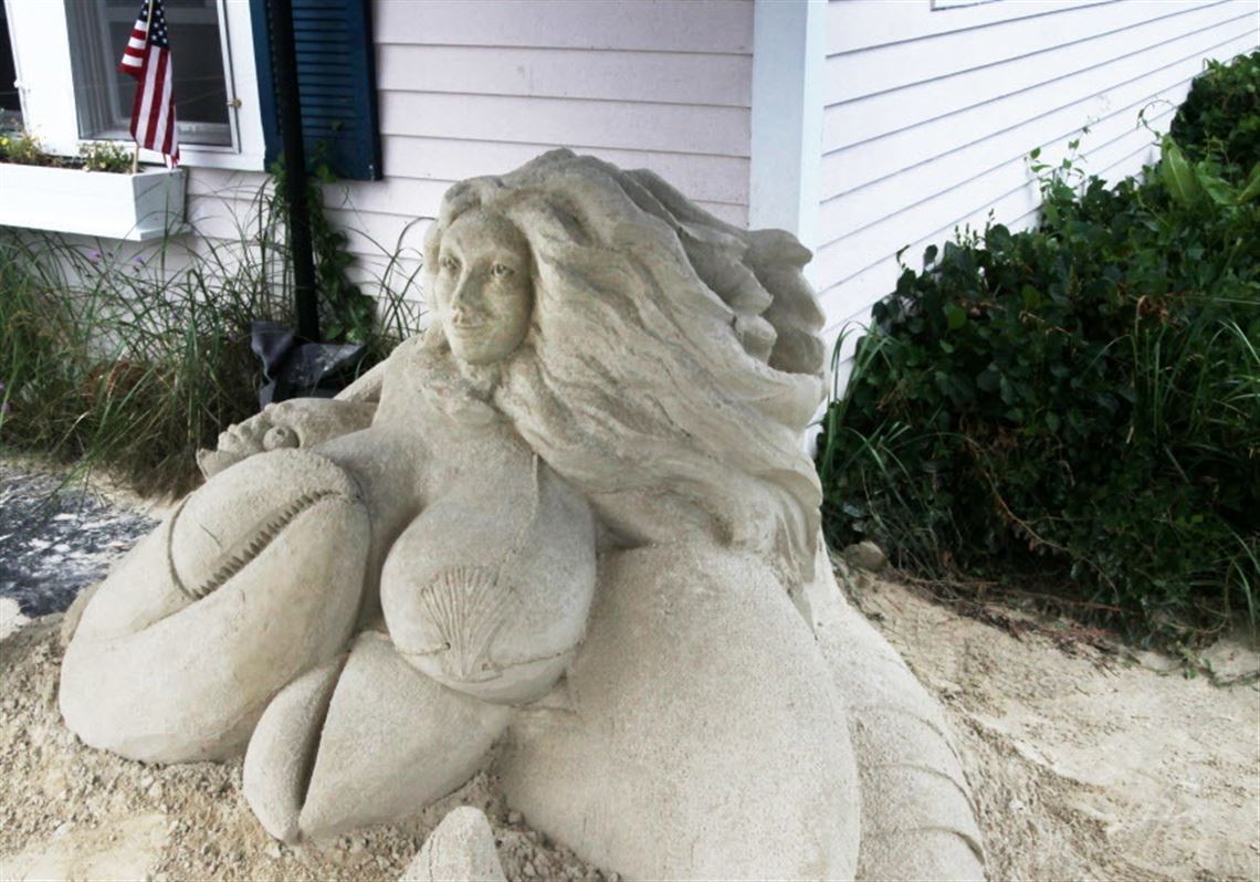 Sand sculpture of busty mermaid draws photo