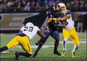 Western Michigan's Jamauri Bogan runs the ball as Toledo defensive backs DeJuan Rogers (23) and Connery Swift (3) attempt to tackle him during last year's game in Kalamazoo.