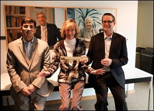 Ahmed Tahir, left, director of strategy and marketing, Robyn Norris, administrative assistant and dean of fun, and James L. Perry, senior vice-president-human resources and organizational excellence at Master Checmical Corp. They are in front of paintings of the company’s founders, Clyde A. Sluhan, left, and his wife, Marian Sluhan.