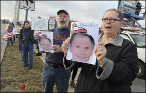 Dennis Mason and his sister, Marilyn Verhelst, both of Grand Rapids, Ohio, demonstrate with others outside Republican U.S. Rep. Bob Latta’s office in Bowling Green. 