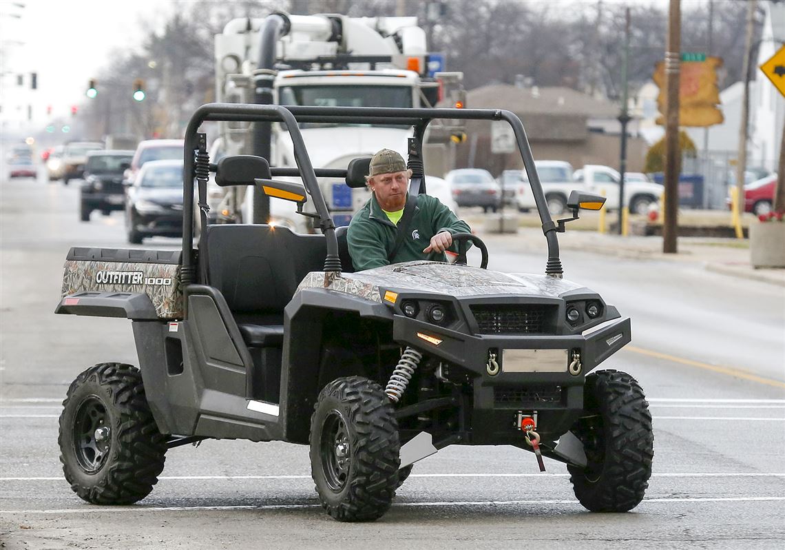 Chris Sabin turns onto Summit Street in Point Place in his gas-powered ‘side-by-side utility vehicle.’ He uses the vehicle to get around the neighborhood. Toledo City Council may approve vehicles such as Mr. Sabin’s for street use in certain areas in Toledo.