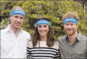 Prince William, left, Kate Duchess of Cambridge and Prince Harry wearing charity headbands. The three royals  are spearheading a campaign to encourage people to talk openly about mental health issues.