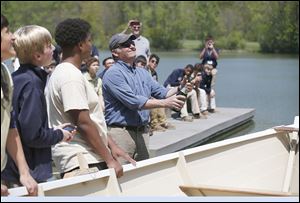 St. John’s Jesuit Academy teacher John May pops a Champagne cork to christen the hand-crafted boat built by students at The Andersons’ pond in Toledo. 
