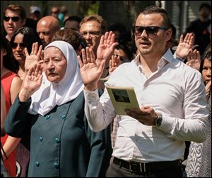 Lutfieh Khalil Al Abbasi , left, from Jordan and Emin Abazoski from Macedonia take the Oath of Citizenship during a Naturalization Ceremony in July 2017 at Sauder Village in Archbold, Ohio.