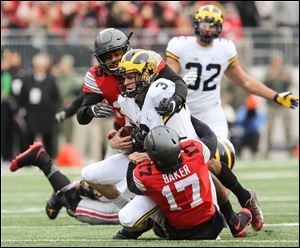 Ohio State's Chris Worley and Jerome Baker take down Michigan quarterback Wilton Speight last season. Speight has started throwing once again, but has not played since a back injury in September.