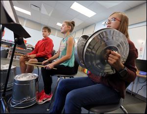 Seventh graders Bryson Richards, 12, Chianna Kujawa 12, and Allsion Launder, 12, play pails and lids in the new music room at West Side Montessori School Thursday, October 19, 2017 in Toledo.