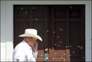 Wilson County Sheriff Joe Tackitt Jr. walks past the front doors where bullet holes were marked by police at the First Baptist Church in Sutherland Springs, Texas.
