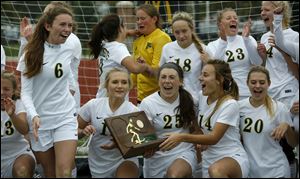 Perrysburg players celebrate with the regional championship trophy. The Yellow Jackets went on to win a state semifinal match over Massillon Jackson this week and will face Loveland Friday in Columbus for a state championship.