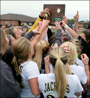 Perrysburg lifts the regional championship trophy last Saturday.