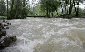 The Ten Mile Creek running through Highland Meadows runs like a raging river due to several days of rain.