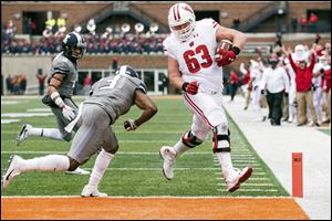 Wisconsin offensive lineman Michael Deiter scores a touchdown in the fourth quarter of a game against Illinois this season. The Genoa graduate's strength and versatility are among the reasons the Badgers are 11-0 this season.