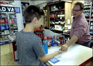 Lucas County Clerk of Courts Bernie Quilter serves a customer during the night shift at Homestead Variety Store in Oregon, Ohio.