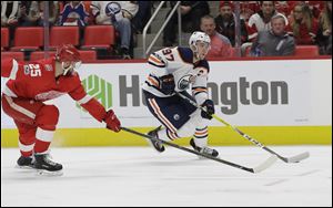 Edmonton Oilers center Connor McDavid controls the puck as he skates by Detroit Red Wings defenseman Mike Green during Wednesday's game in Detroit.