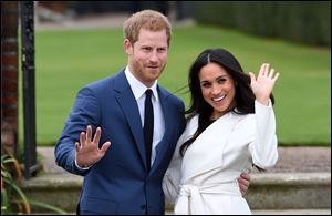 Britain's Prince Harry and Meghan Markle pose for the media in the grounds of Kensington Palace in London on Monday, Nov. 27.