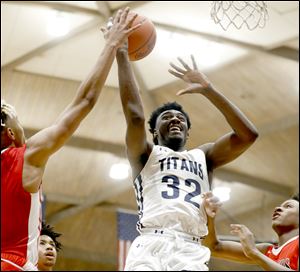 Vincent Williams, Jr. of St. John's Jesuit drives to the basket Friday against Rogers. Williams scored the 1,000th point of his prep career, and the Titans rolled to a season-opening 89-52 victory.