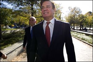 In this Nov. 2, 2017, file photo, Paul Manafort accompanied by his lawyers, arrives at U.S. Federal Court, in Washington. Prosecutors say Manafort has been working on an op-ed with a longtime colleague 