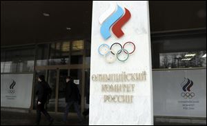 People walk past the building of Russian Olympic Committee in Moscow. The International Olympic Committee has barred the Russian team from competing at the Winter Olympics in Pyeongchang, South Korea in February over widespread doping at the last Winter Games in 2014.