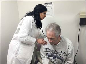 Dr. Kamala Tamirisa, left, uses a stethoscope to check Tom Evans at ProMedica Monroe Regional Hospital. Mr. Evans was the first in the Toledo area to receive a leadless pacemaker, which is smaller and doesn't require the wires of a traditional pacemaker.  