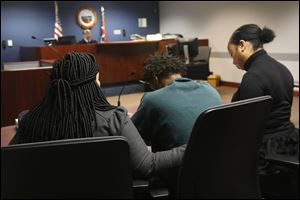 Demetrius Wimberly, 14, center, is comforted as he is arraigned on the charge of murder Wednesday, December 27, 2017, at Lucas County Juvenile Court in downtown Toledo. 