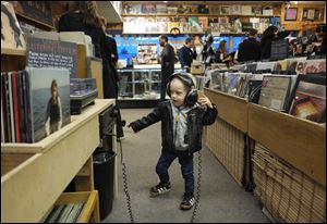 Desmond Anderson, 2, checks out the Vinyl Listening Station during a memorial and tribute jam session for Culture Clash's owner Pat O'Connor at the West Toledo store, Tuesday, January 03.