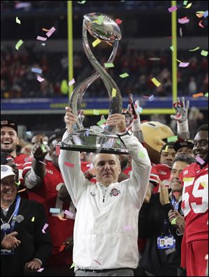Ohio State coach Urban Meyer lifts the trophy after the Buckeyes defeated Southern California in the Cotton Bowl, 24-7.