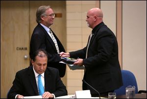 Former board president David Hunter, left, shakes new board president Thomas Ilstrup's hand during Wednesday's meeting of the Washington Local school board.