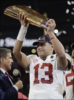 Alabama's Tua Tagovailoa holds up the championship trophy after defeating Georgia in January.