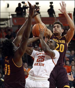 Bowling Green State University's Daeqwon Plowden tries to power through Central Michigan defenders Innocent Nwoko, left, and Kevin McKay during Saturday's game at the Stroh Center in Bowling Green.