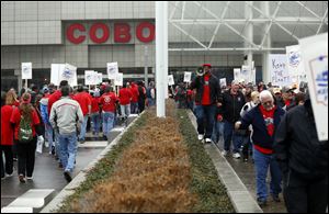 Brian Sims, UAW Local 12 Committeeman, leads a demonstration outside of the Cobo Center with about 200 members of UAW Local 12 to draw attention to Fiat Chrysler's decision to outsource some trucking work that had previously been done by UAW in Toledo.