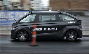 A Navya Autonom Cab, a self-driving vehicle, drives down a street during a demonstration at CES International in Las Vegas.