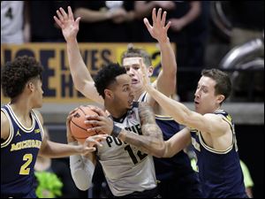 Purdue forward Vincent Edwards is stopped by Michigan's Duncan Robinson, right, and Moritz Wagner during Thursday's Big Ten game at Purdue. 
