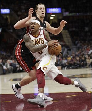 Cleveland Cavaliers' Isaiah Thomas, left, drives to the basket against Miami Heat's Kelly Olynyk.