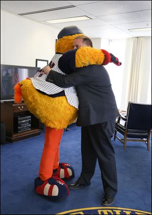 Toledo Mayor Wade Kapszukiewicz gets a hug from Muddy the Mud Hen in his office at One Government Center on Friday. The mayor performed as Muddy during 1991.