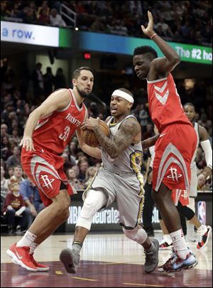 Cleveland Cavaliers' Isaiah Thomas, center, drives between Houston Rockets' Ryan Anderson, left and Clint Capela.