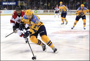 Toledo's Kevin Gibson controls the puck in front of Cincinnati's Winston Day Chief during a game between the Toledo Walleye and Cincinnati Cyclones at the Huntington Center in Toledo on Jan. 28, 2018.