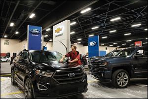 Rob Shobe cleans a Ford Edge that had been driven to from Detroit in the snow for the Greater Toledo Auto Show. The 2018 Greater Toledo Auto Show starts Thursday at the SeaGate Convention Centre and runs through Sunday, February 11.    The Blade/Jetta Fraser