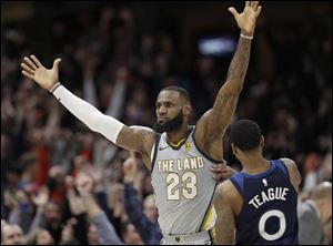 Cleveland Cavaliers' LeBron James celebrates after making the game-winning basket in overtime to beat the Minnesota Timberwolves.