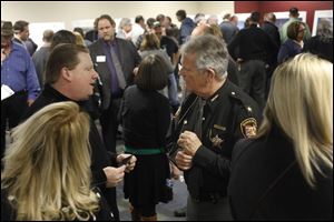 Jay Merritt, left, talks with Lucas County Sheriff John Tharp during an open information session on a proposed new Lucas County Jail Wednesday at the Lucas County EMS building in Toledo. 