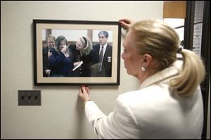 Lucas County Prosecutor Julia Bates adjusts a photo hanging on the Lucas County Prosecutor's Office wall from the Cook brothers case in 2000 at the Lucas at the Lucas County Courthouse in Toledo on Monday, January 29, 2018. 